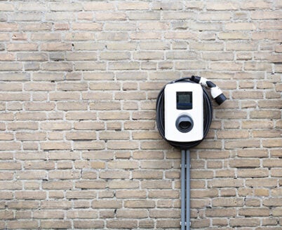New charging station for electric car on brick wall at home, charging pillar with copy space ,